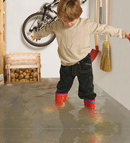 Ein Kind spielt im Hochwasser im Keller